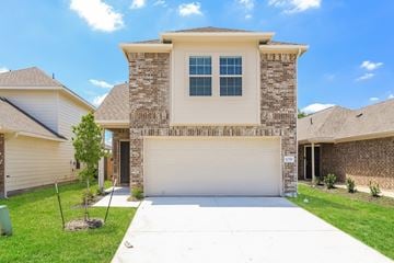 Houston apartment for rent - a beige house with a white driveway and a garage door