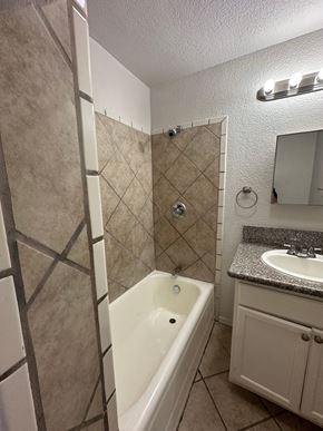 San Bernardino apartment for rent - a bathroom with a tub and a sink and a mirror