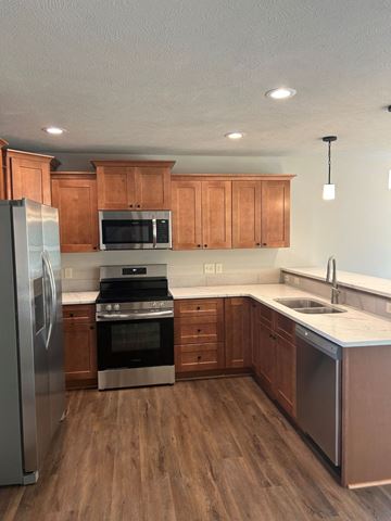 Lincoln house for rent - a kitchen with wooden cabinets and stainless steel appliances