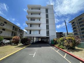 Honolulu apartment for rent - A white building with a red line on the ground in front of it.