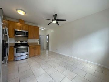 Honolulu apartment for rent - A kitchen with a refrigerator, microwave, oven, and a ceiling fan.