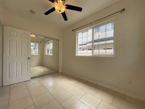 Honolulu apartment for rent - A room with a ceiling fan and a sliding glass door.