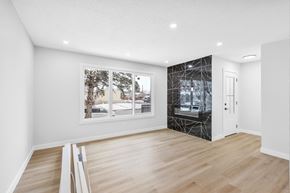 Calgary apartment for rent - a living room with white walls and a window and a glass closet
