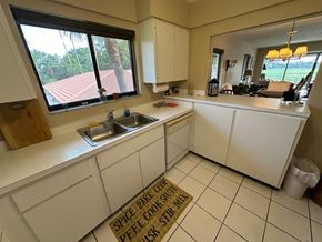 Bradenton house for rent - a kitchen with white cabinets and a sink and a window