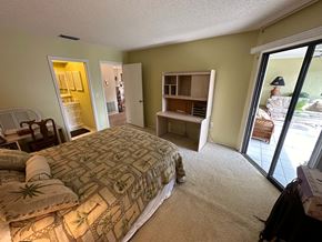 Bradenton house for rent - a bedroom with a large bed and a sliding glass door