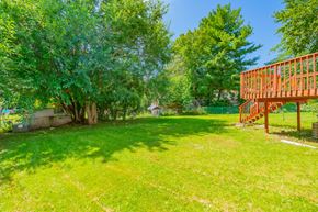 Madison house for rent - A backyard with a wooden structure and trees.