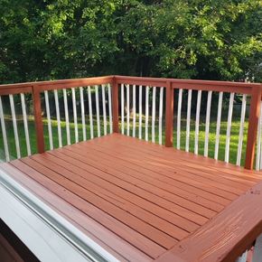 Madison house for rent - A wooden deck with white railings and a green lawn in the background.