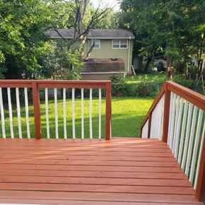 Madison house for rent - A wooden deck with a white railing and a green lawn.
