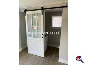 Knoxville house for rent - A white door with a glass window and a black handle is shown.