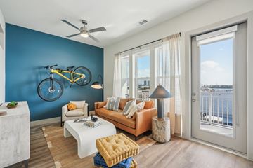Tampa apartment for rent - A living room with a yellow sofa and a bicycle on the wall.
