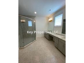 Loudon house for rent - A spacious bathroom with a glass shower stall and a vanity with a countertop.