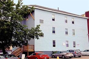 Worcester apartment for rent - a large white building with cars parked in front of it