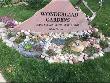 Boulder apartment for rent - A garden sign that says "Wonderland Gardens" is in front of a garden.