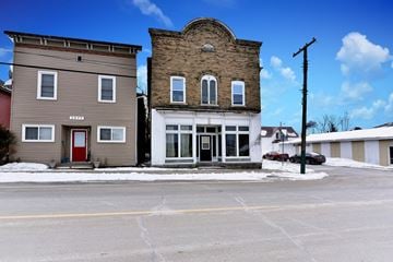 Cardinal apartment for rent - A building with a red door is situated in front of a building with a white door.
