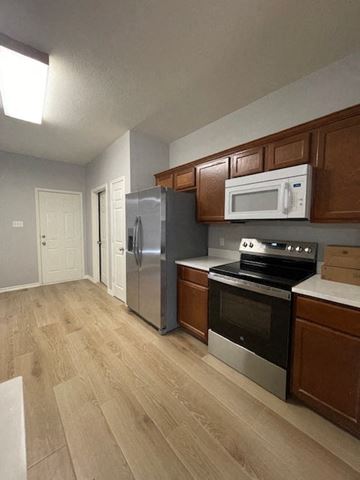 Temple house for rent - a kitchen with stainless steel appliances and wooden cabinets