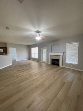 Temple house for rent - an empty living room with a fireplace and a ceiling fan