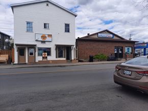 Chesterville apartment for rent - A car is parked on the side of the road in front of a white building with a sign that reads "Pharmacy Choice.".