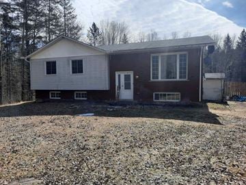 Pembroke apartment for rent - A house with a brown and white exterior is surrounded by a gravel area.