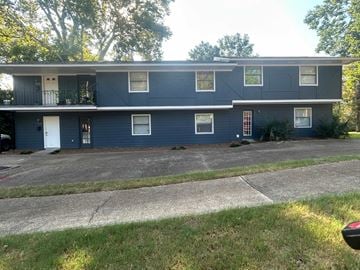 Jackson, Ms apartment for rent - the front of a blue house with a driveway and grass