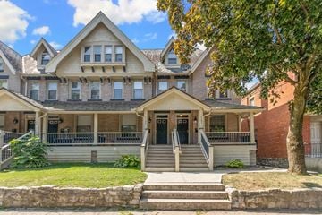 Columbus apartment for rent - A large house with a front porch and a tree in front.