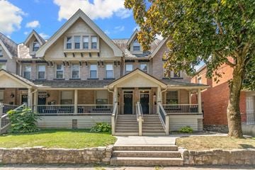 Columbus apartment for rent - A large house with a front porch and a tree in front.