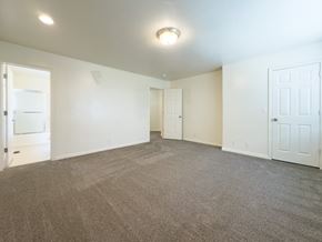 Orem house for rent - A spacious room with carpeted floor and white walls.