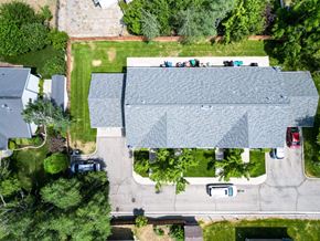 Orem house for rent - A large building with a grey roof is surrounded by a grassy area and trees.