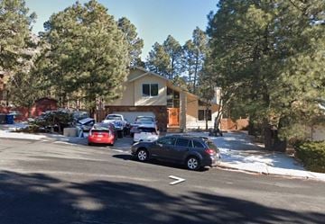 Flagstaff house for rent - a house with cars parked in a parking lot