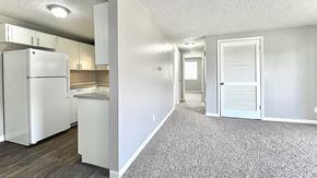 Greeley apartment for rent - A kitchen with a white refrigerator and a white door leading to another room.