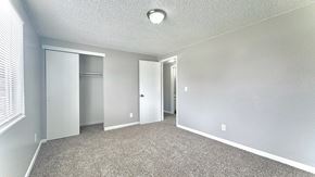 Greeley apartment for rent - a bedroom with white walls and a wood floor and a closet