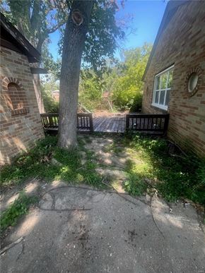 Saint Louis house for rent - the backyard of a brick house with a tree and a pathway