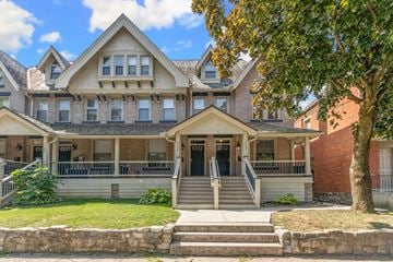 Columbus apartment for rent - A large house with a front porch and a tree in front.