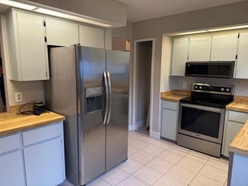 Orlando house for rent - a kitchen with stainless steel appliances and white cabinets