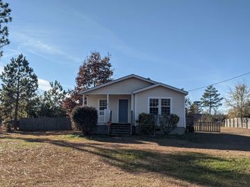 Opelika house for rent - a small white house with a yard and a fence
