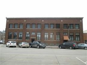 Grinnell apartment for rent - A parking lot with cars and a building in the background.