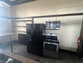 Grinnell apartment for rent - A kitchen with a black refrigerator, stove, and oven.