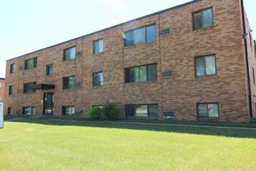 Moorhead apartment for rent - a brick building with a green lawn in front of it