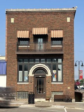 Grinnell apartment for rent - A red brick building with a balcony on the second floor.
