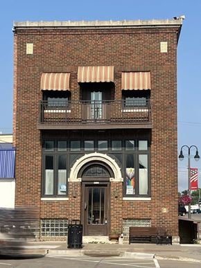 Grinnell apartment for rent - A red brick building with a balcony on the second floor.