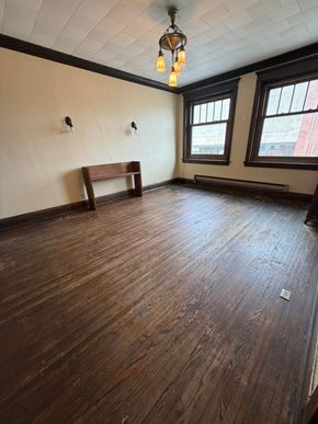 Grinnell apartment for rent - A room with wooden floors and a bench.