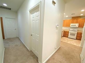 Merced house for rent - A white door is in a hallway leading to a kitchen.