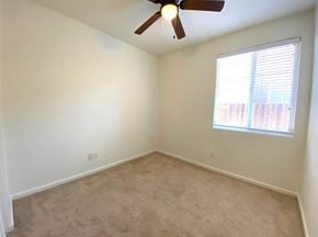 Merced house for rent - A room with a ceiling fan and a window with blinds.