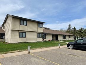 Eagle Bend apartment for rent - a yellow house with a black car parked in a parking lot