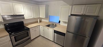 Plantation apartment for rent - A kitchen with white cabinets and stainless steel appliances.