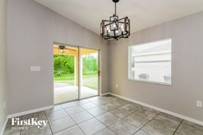 Winter Haven house for rent - an empty dining room with a chandelier and a door to the yard