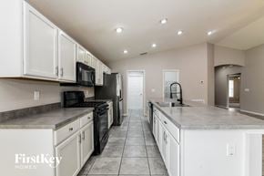 Winter Haven house for rent - a large kitchen with white cabinets and black appliances