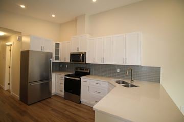 Edmonton house for rent - a kitchen with white cabinets and stainless steel appliances