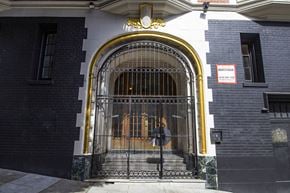 San Francisco apartment for rent - A black and white building with a gold arched entrance and a sign that says "MENENSOR".