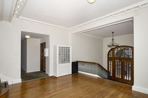 San Francisco apartment for rent - A room with a wooden floor and a staircase with a metal railing.