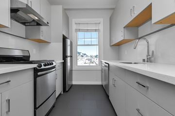 San Francisco apartment for rent - A modern kitchen with white cabinets and a stainless steel stove.